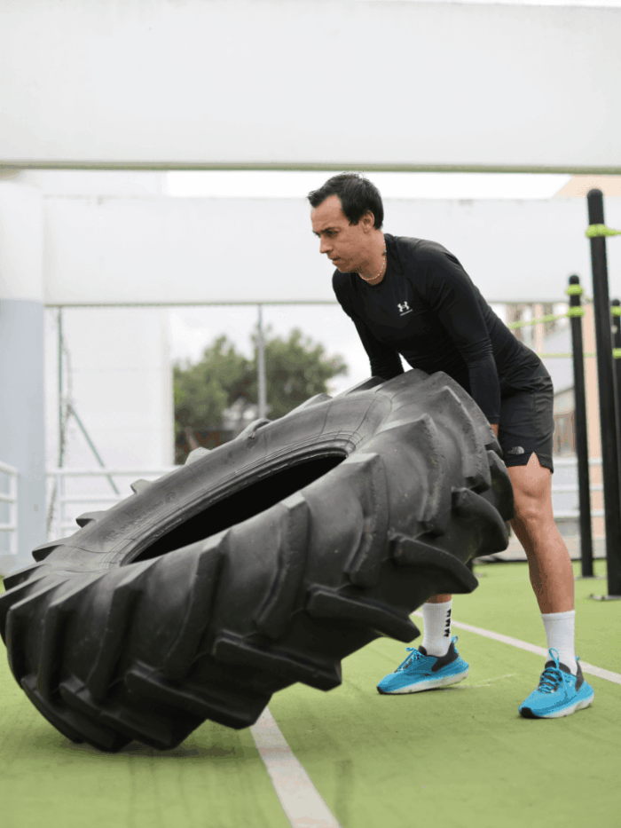 άνδρας γυμνάζεται σπρώχνοντας μεγάλο ελαστικό εμπόδιο